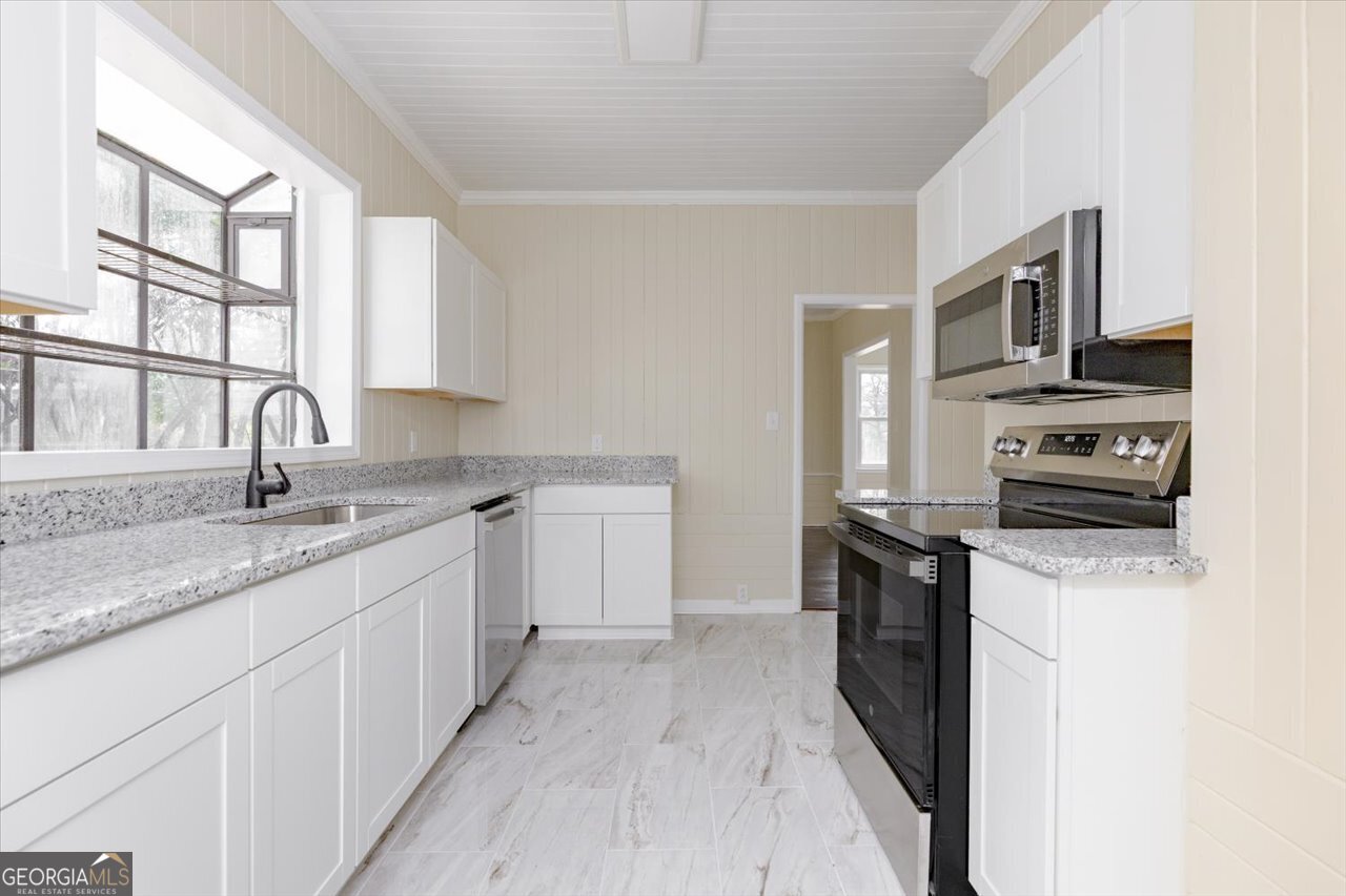 1205 Swift Street Perry, GA 31069 - Photo 25 of 63 a kitchen with stainless steel appliances granite countertop a sink stove and refrigerator
