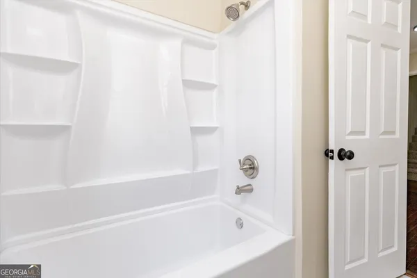 a white bath tub sitting next to a shower