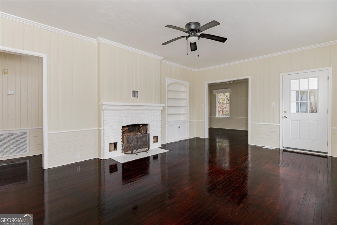 1205 Swift Street Perry, GA 31069 - Photo 9 of 63 a living room with wooden floors and a fireplace