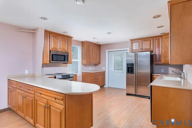 a kitchen with stainless steel appliances granite countertop a sink stove refrigerator and cabinets