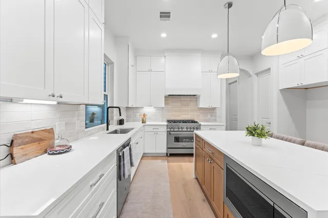 a kitchen with white cabinets and stainless steel appliances