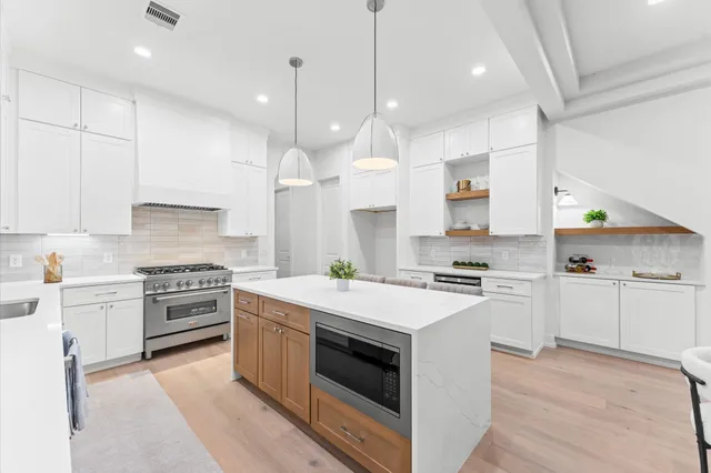 a kitchen with a dining table chairs and white cabinets