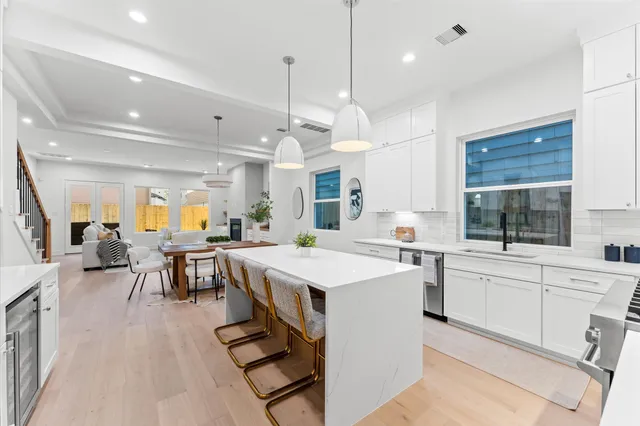 a kitchen with a stove a refrigerator a sink and chairs