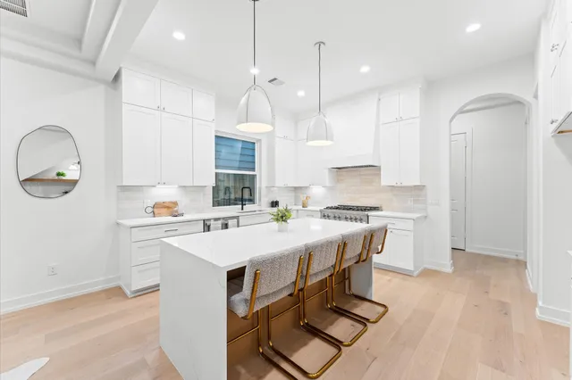 a kitchen with stainless steel appliances granite countertop a sink a stove and a refrigerator