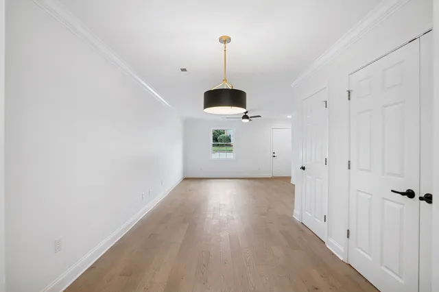 a view of a room with wooden floor and windows