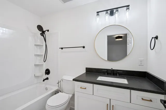 a bathroom with a sink a toilet and a mirror