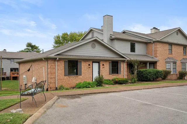 a front view of a house with a yard and potted plants