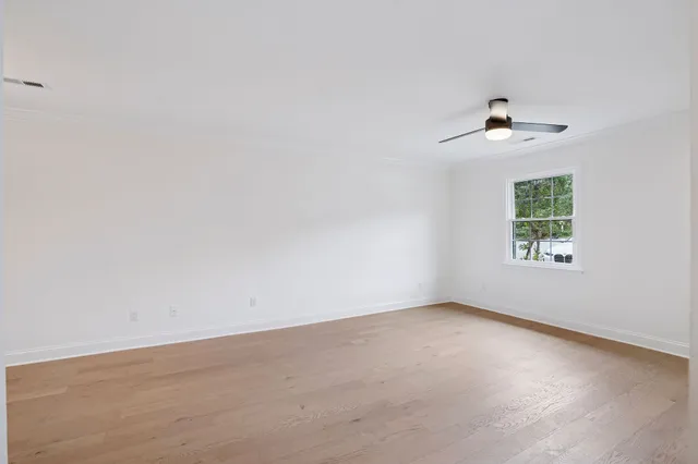 an empty room with a window and a ceiling fan