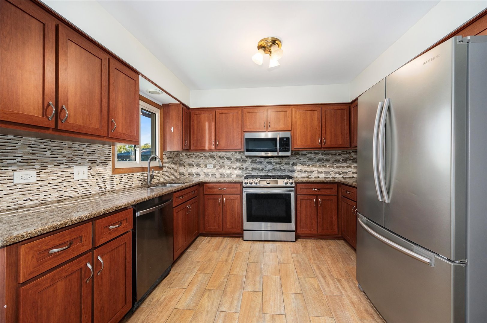 1228 Honey Hill Road Addison, IL 60101 - Photo 13 of 41 a kitchen with stainless steel appliances granite countertop a refrigerator sink and stove