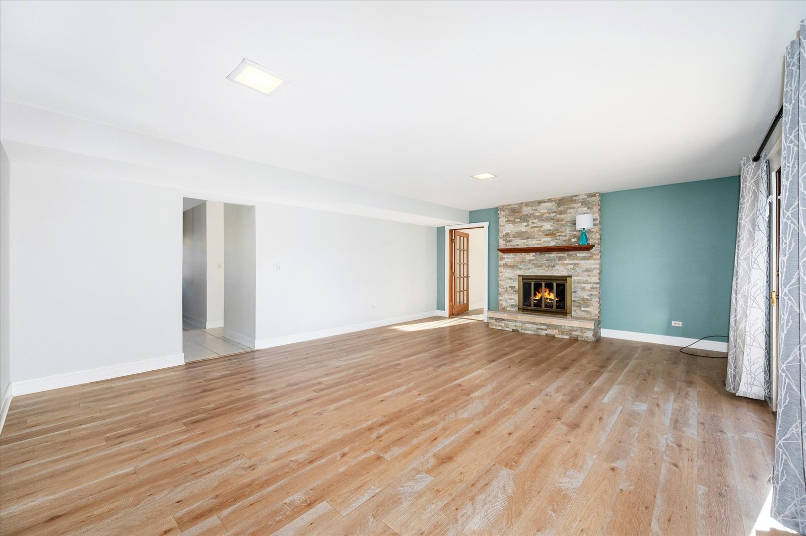 1228 Honey Hill Road Addison, IL 60101 - Photo 16 of 41 an empty room with wooden floor a fireplace and a window