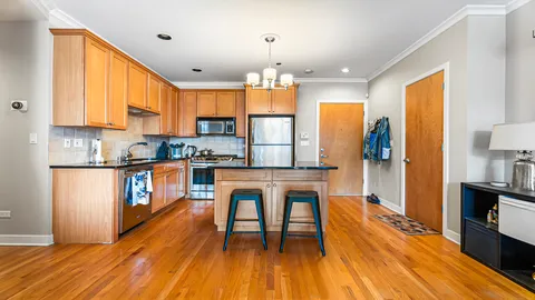 a kitchen with granite countertop wooden floors and stainless steel appliances