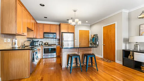 a kitchen with wooden floors and wooden cabinets