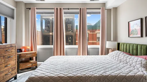 a bedroom with a bed and a large window