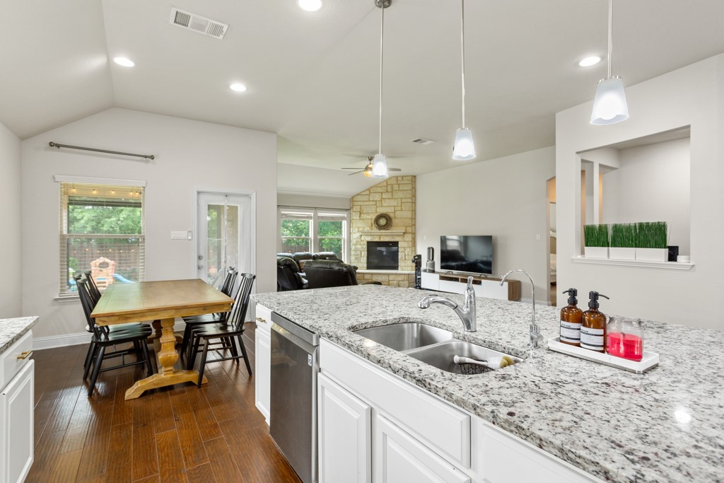1916 Elaina Loop Leander, TX 78641 - Photo 12 of 23 a kitchen with granite countertop a sink a counter top space and living room view