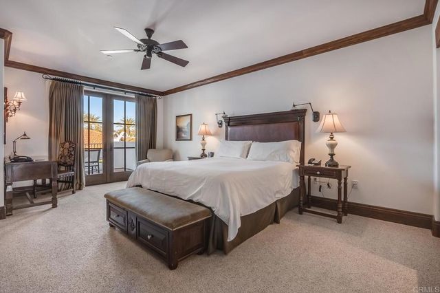 a spacious bedroom with a bed a chandelier and large window
