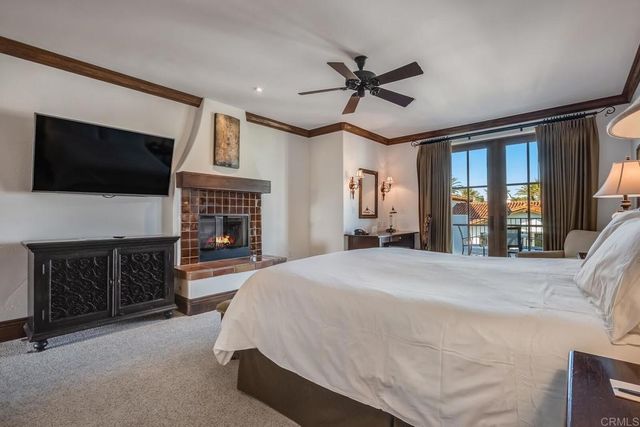 a spacious bedroom with a bed and a flat screen tv