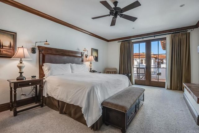 a bedroom with a large bed and a chandelier fan