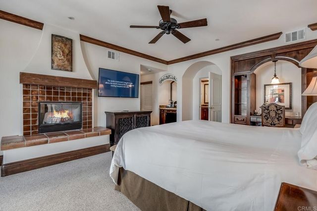 a bedroom with a bed and a fireplace with a bookshelf