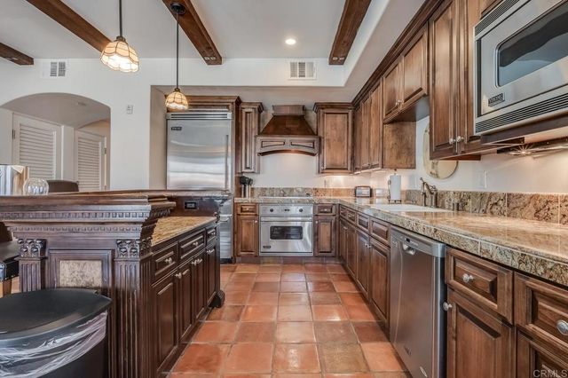 a kitchen with stainless steel appliances granite countertop a stove a sink and a refrigerator