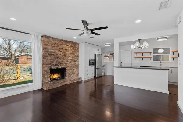 a view of a kitchen with furniture a fireplace and wooden floor