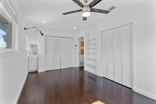 a view of empty room with wooden floor and window