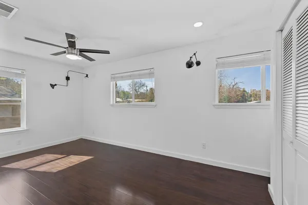 a view of empty room with wooden floor