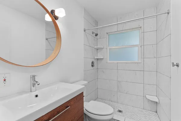 a bathroom with a sink a toilet and shower