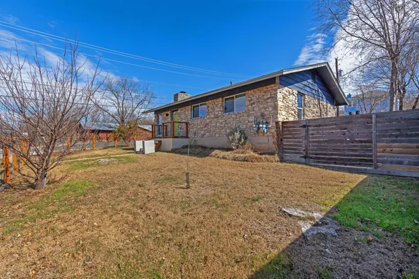 a view of a yard with wooden fence
