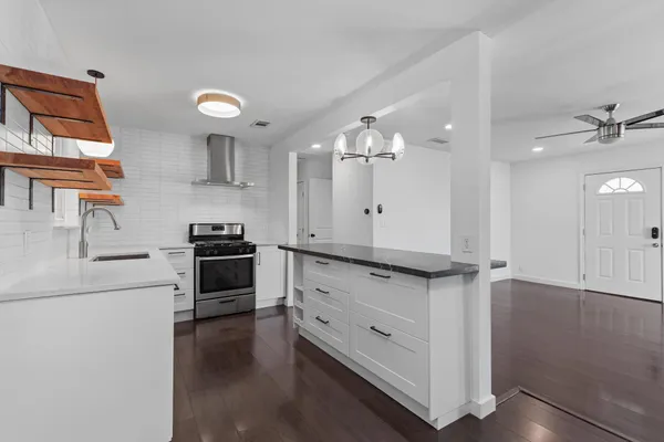 a kitchen with stainless steel appliances a sink cabinets and wooden floor