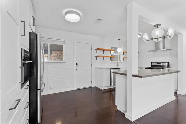 a kitchen with stainless steel appliances granite countertop a refrigerator and a stove top oven