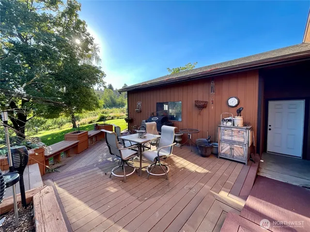 a view of a patio with table and chairs with wooden floor and fence