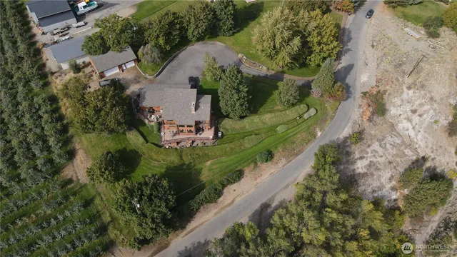 an aerial view of a house with a yard and lake view