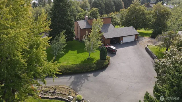 an aerial view of a house with a garden and trees