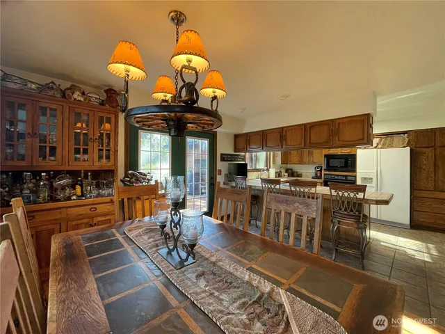 a living room with stainless steel appliances furniture a rug and a kitchen view