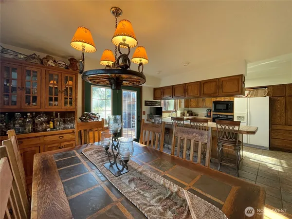 a living room with stainless steel appliances furniture a rug and a kitchen view