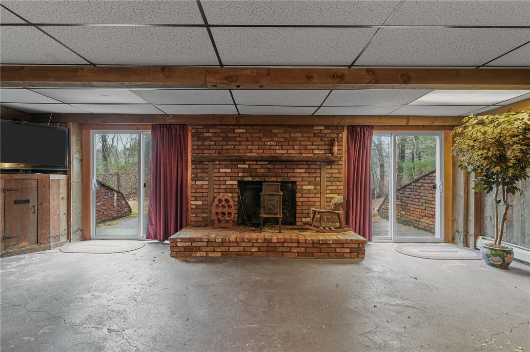 30 Sheffield Hill Road Exeter, RI 02822 - Photo 27 of 42 Stone fireplace in the basement, sliders on either side to paito