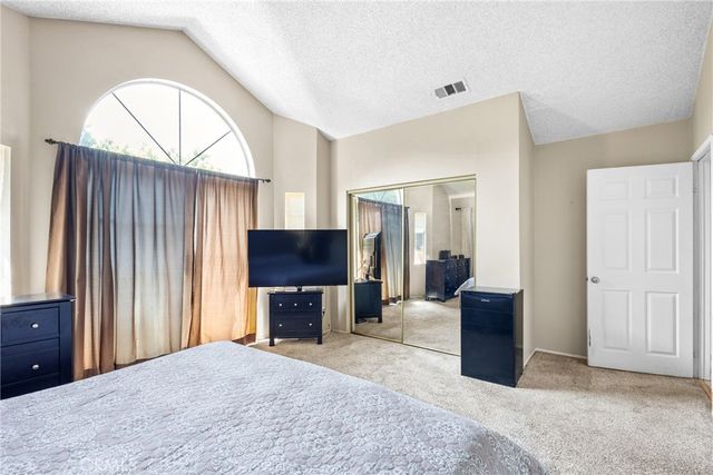 a bedroom with a bed and a television