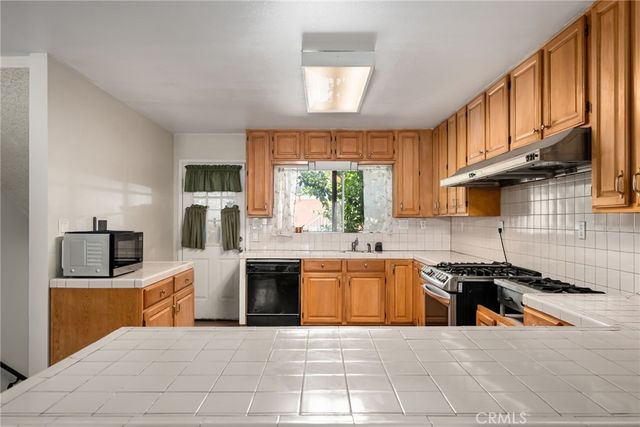a large kitchen with stainless steel appliances granite countertop a stove and a sink