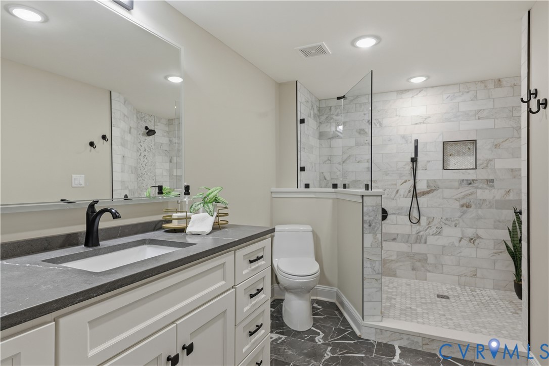 2956 Hathaway Road, Unit 609 Richmond, VA 23225 - Photo 20 of 32 a bathroom with a granite countertop sink a toilet a mirror and shower