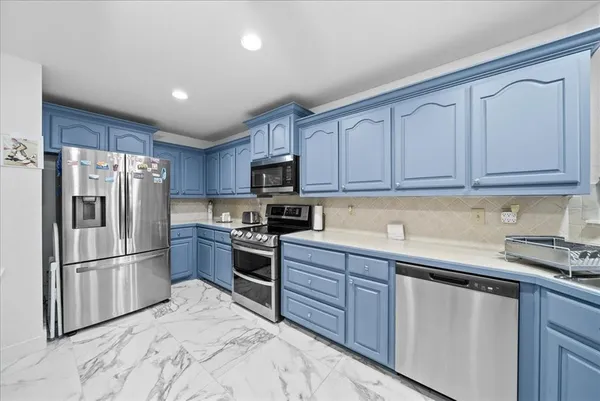 a kitchen with granite countertop stainless steel appliances and wooden cabinets