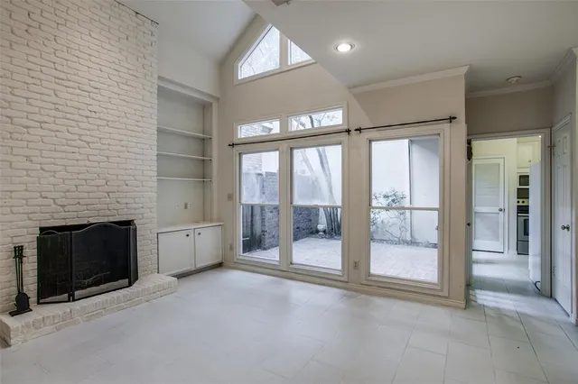 a view of an empty room with a fireplace and a window