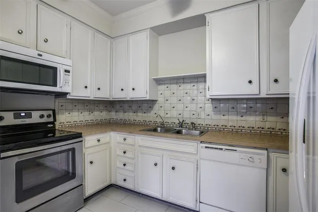 a kitchen with granite countertop white cabinets and stainless steel appliances