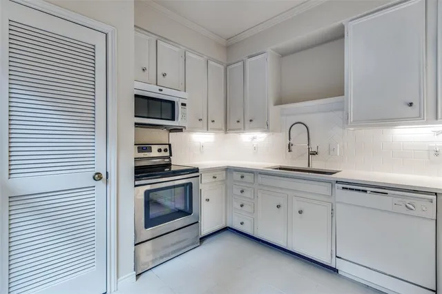 a kitchen with white cabinets stainless steel appliances and sink