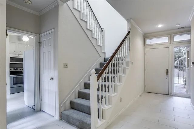 a view of staircase with lots of frames and white walls