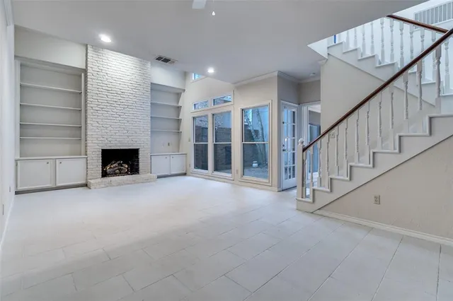 a view of an empty room with a fireplace and a window