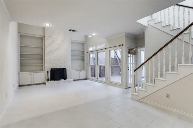a view of an empty room with a fireplace and a window