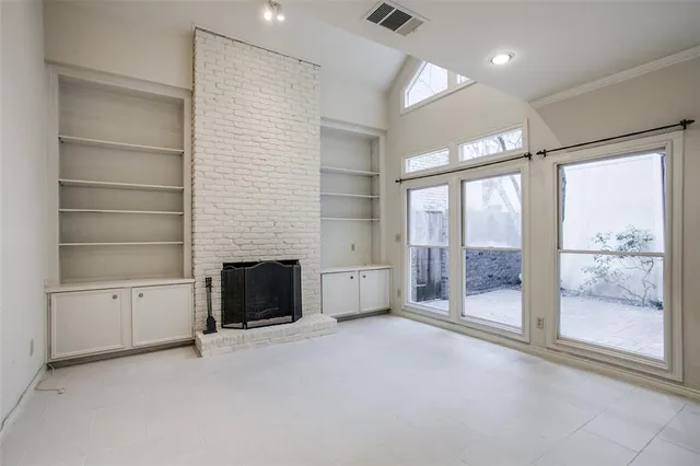 a view of an empty room with a fireplace and a window