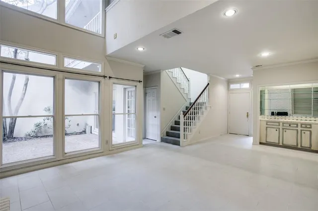 an empty room with windows and stairs