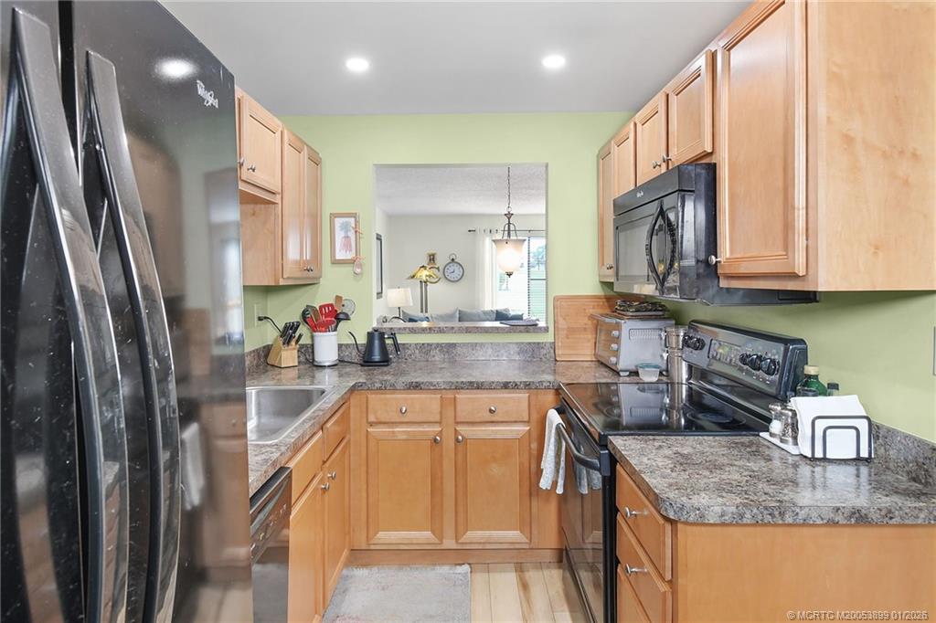 5403 Southeast Miles Grant Road, Unit H111 Stuart, FL 34997 - Photo 13 of 57 a kitchen with stainless steel appliances granite countertop a sink refrigerator and cabinets