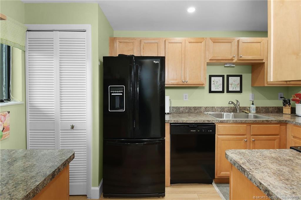 5403 Southeast Miles Grant Road, Unit H111 Stuart, FL 34997 - Photo 14 of 57 a kitchen with a granite countertop refrigerator sink and cabinets